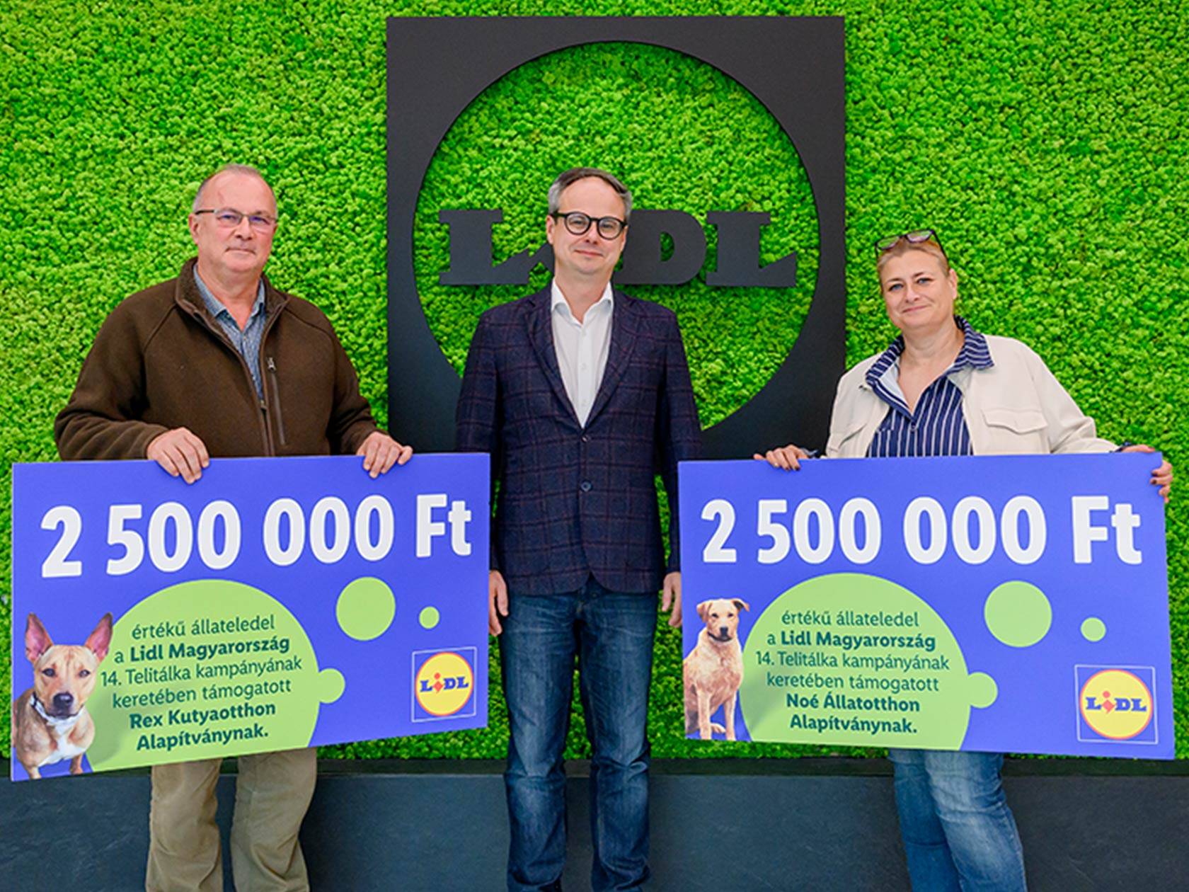 Három ember tart két táblát, amelyeken 2 500 000 Ft értékű állateledel adomány szerepel a Lidl Hungarianország Telitálka kampányából.