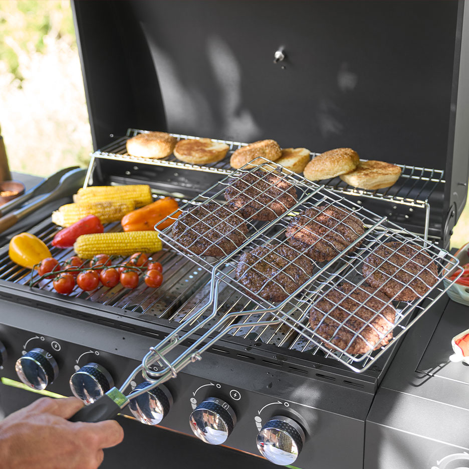 Gázgrill hamburgerekkel, kukoricacsövekkel és zsemlékkel a rácson.